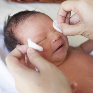 Мама промывает глазки малышу Чем лечить конъюнктивит у грудничка?